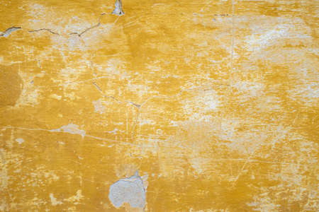 damaged weathered multicolored coating of paint of concrete building wall with many patchesの写真素材