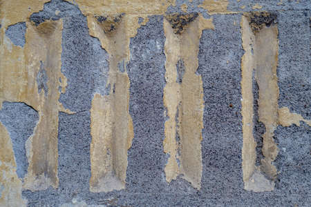 damaged weathered concrete coating of fainted paint of building wall with many patchesの写真素材