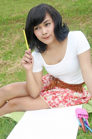 Young woman painting in the park の写真素材