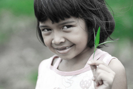 Young asian child holding a plant in her hand の写真素材