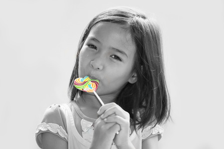 a little girl eating a lollipopの写真素材