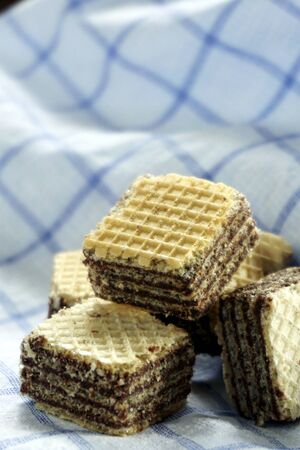 Filled wafer cubes Milk chocolate cream on a wooden table in the morning lightの写真素材