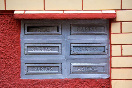 Old postboxes on red white wall in Brazil