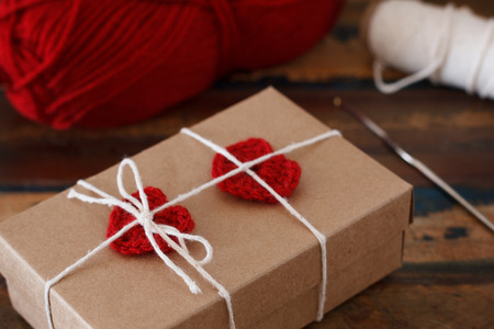 Saint Valentine decoration: handmade crochet red heart on gift paper box. Selective focusの写真素材