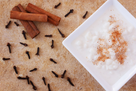 Brazilian dessert canjica of white corn with cinnamon in white plate. Selective focus on canjicaの写真素材