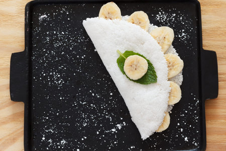 Casabe (bammy, beiju, bob, biju) - flatbread made from cassava (tapioca) with banana on pan. Selective focus. Copy spaceの写真素材