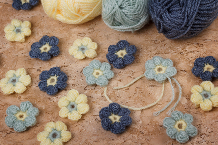 Handmade colorful crochet flower with skein on marble table. Selective focusの写真素材