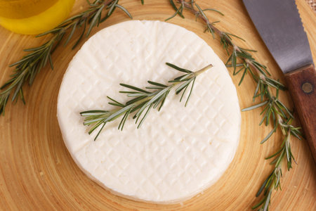 Wheel of brazilian traditional cheese Minas on wooden board with olive oil. Selective focusの写真素材
