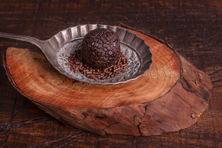 Brazilian chocolate truffle bonbon brigadeiro on wooden table. Selective focus