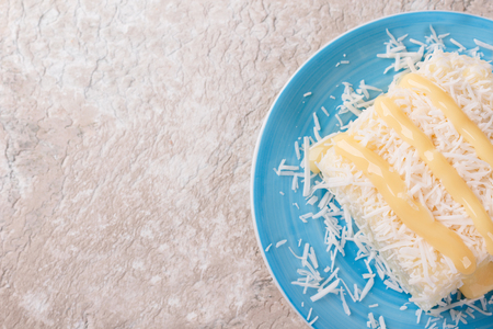 Brazilian traditional dessert: sweet couscous (tapioca) pudding (cuscuz doce) with coconut and  condensed milk on marble table. Selective focus. Copy spaceの写真素材