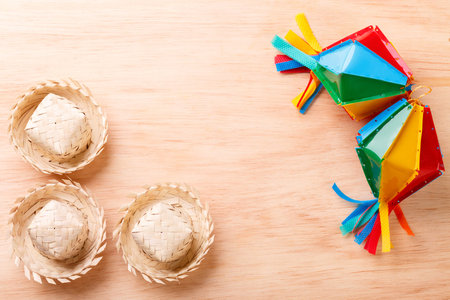 Wooden background with wicker hat for brazilian festivel Festa Junina, copy space