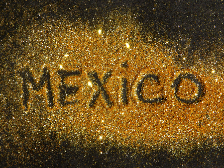 Blurry inscription Mexico on golden glitter sparkle on black backgroundの写真素材