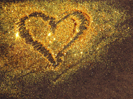 Heart of golden glitter on black backgroundの写真素材