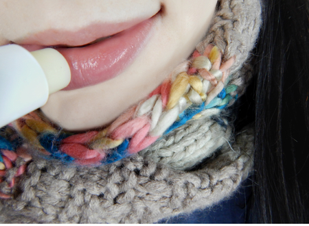 Young woman using hygienic lipstickの写真素材