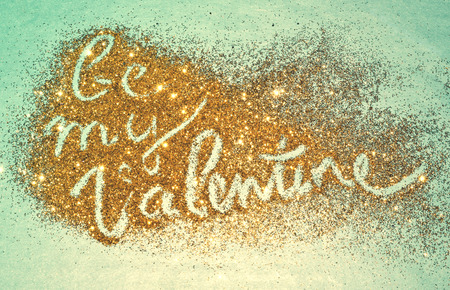 Text Be My Valentine of golden glitter sparkles on blue backgroundの写真素材