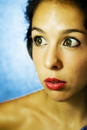 Face of beautiful young woman on blue backgroundの写真素材