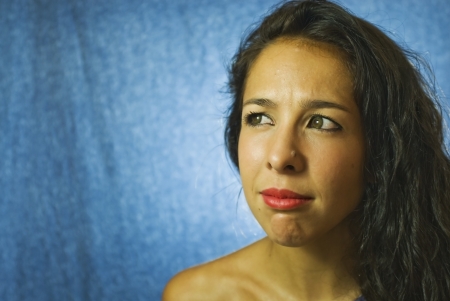 Face of beautiful young woman on blue backgroundの写真素材