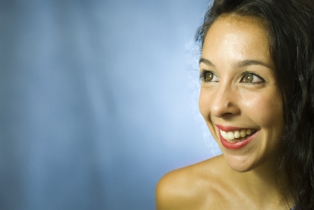 Face of beautiful young woman on blue backgroundの写真素材