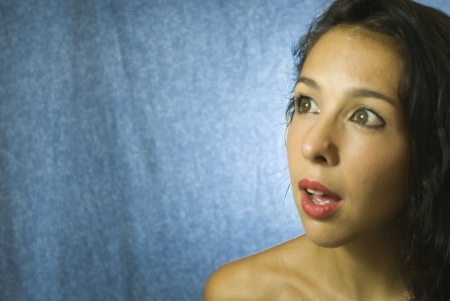 Face of beautiful young woman on blue backgroundの写真素材