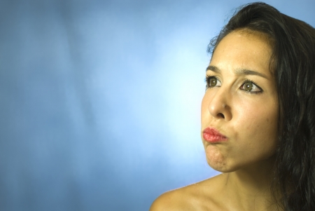 Face of beautiful young woman on blue backgroundの写真素材
