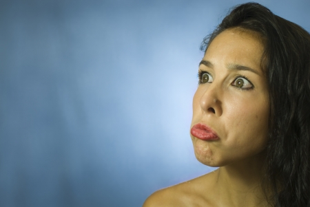 Face of beautiful young woman on blue backgroundの写真素材