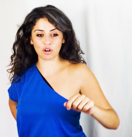Portrait of a young woman with blue shirt, jeans and white backgroundの写真素材