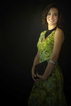 Beautiful woman with green dress on black backgroundの写真素材