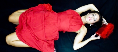 Beautiful woman with red dress on black backgroundの写真素材