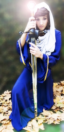 Portrait of a beautiful medieval woman with a shining swordの写真素材