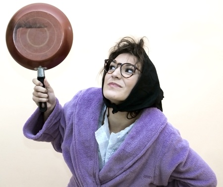 Old woman with frying panの写真素材