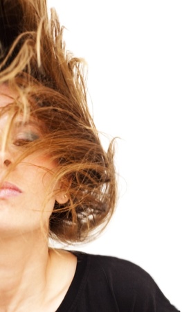 Portrait of young beautiful woman with black shirt moving hair on white backgroundの写真素材