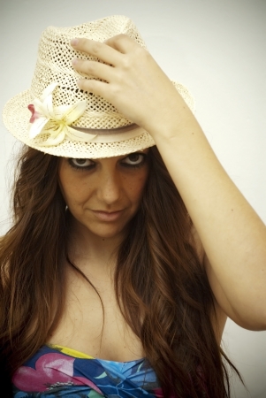 Portrait of beautiful young woman with colored shirt and hat on white backgroundの写真素材