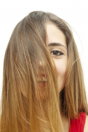 Portrait of a young  woman with red shirt and her hair in the wind over white backgroundの写真素材