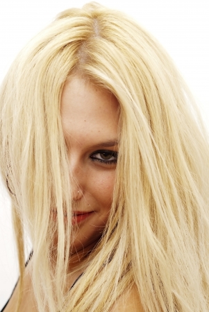 Wonderful blonde woman with her hair over her face on white backgroundの写真素材
