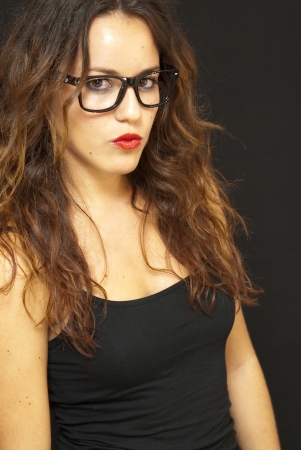 Portrait of an attractive woman with glasses on black backgroundの写真素材