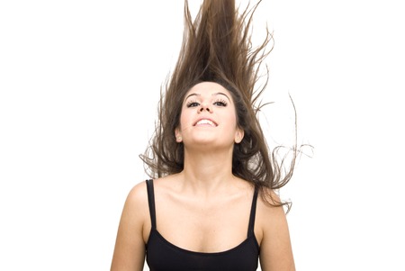 Beautiful Brunette Girl with her hair flying over white backgroundの写真素材