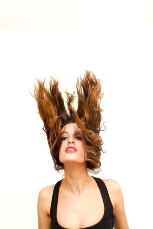 Beautiful Brunette Girl with her hair flying over white backgroundの写真素材