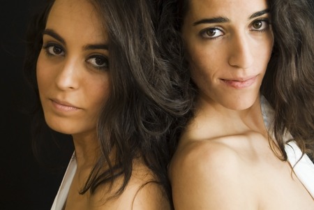Portrait of  Two Friends Brunettes Women With  White Shirts of Man  over black の写真素材
