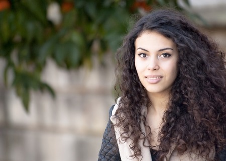 Beautiful latin woman in a park in autumnの写真素材