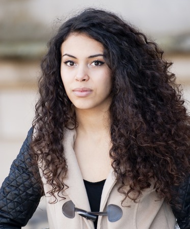 Beautiful latin woman in a park in autumnの写真素材