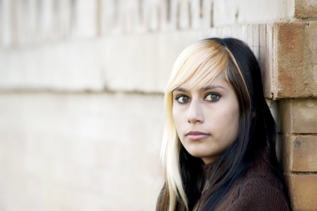 Beautiful  Girl leaning against a wall in the parkの写真素材