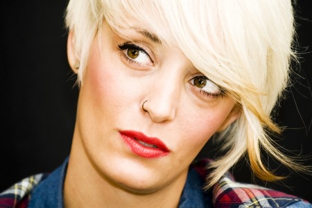 Beautiful woman with denim shirt and short white hair on black backgroundの写真素材