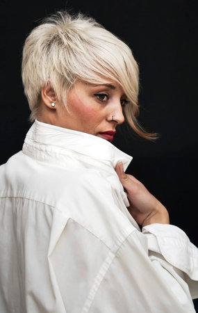 Beautiful woman with white man's shirt and short white hair on black background