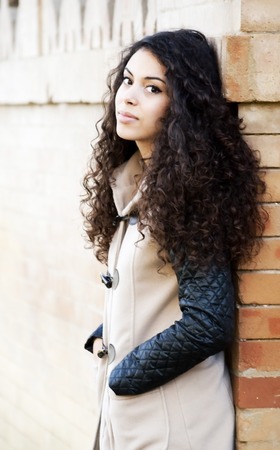 Beautiful  Latin Girl leaning against a wall in the parkの写真素材