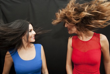 Two beautiful friends waving hairの写真素材