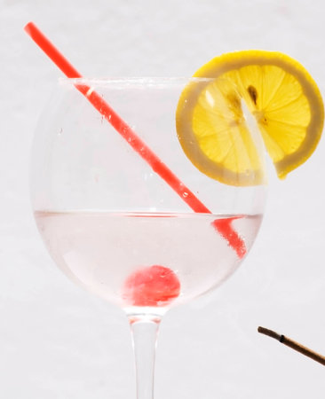 Cocktail with lemon slice, cherry and a strawの写真素材