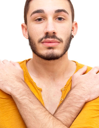Handsome guy hugging himself  with beard on white backgroundの写真素材