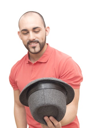 handsome guy with beard looking into his hat on white backgroundの写真素材
