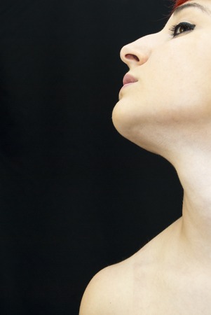 Portrait of young beautiful woman with red hair on black backgroundの写真素材