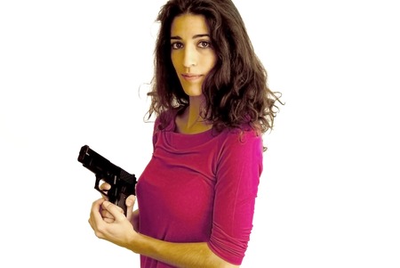 Portrait of Beautiful Young Woman With Gun Over White Backgroundの写真素材